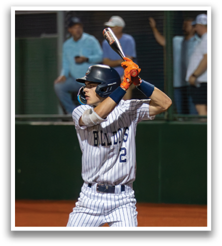 A baseball player in a blue and white uniform is holding a bat and getting ready to swing. Contenido generado con IA
