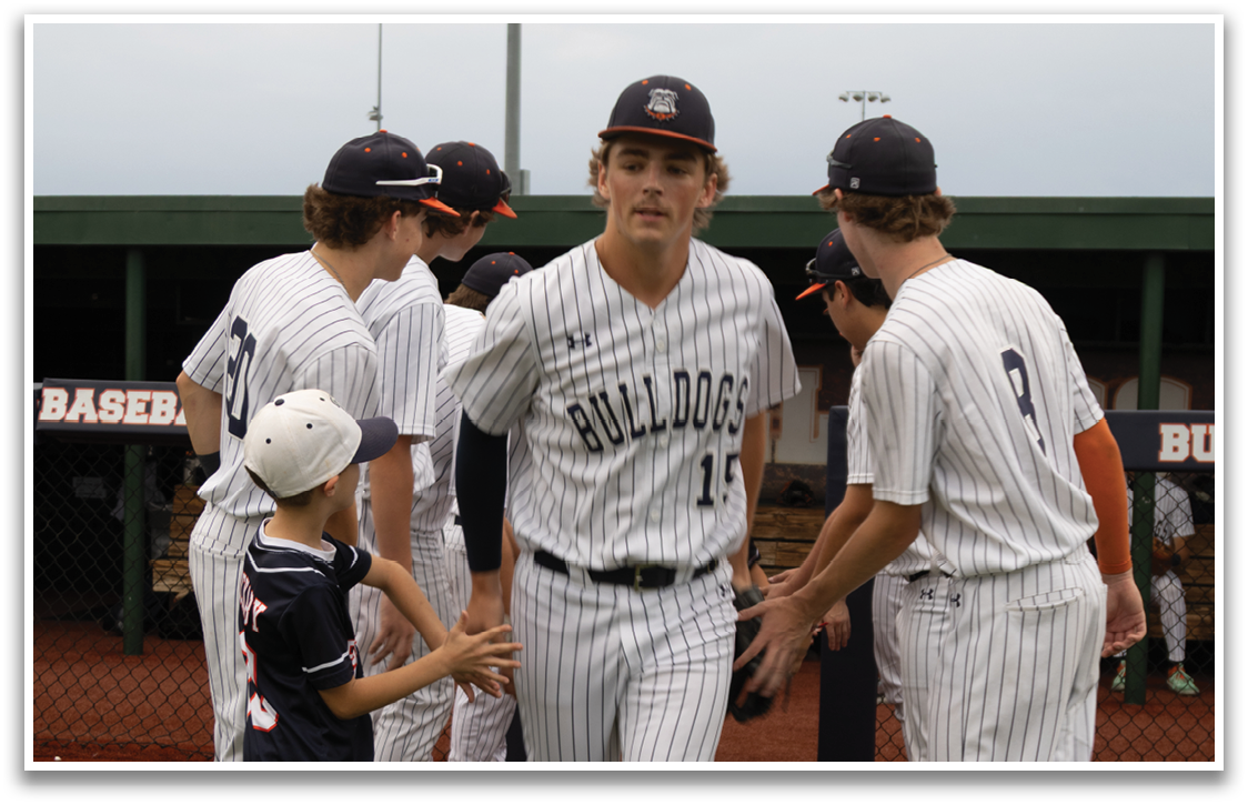 A group of baseball players are on the field, with one player walking towards a young boy. The boy is wearing a blue shirt and a baseball cap. The players are wearing baseball gloves and are in various positions on the field. Contenido generado con IA