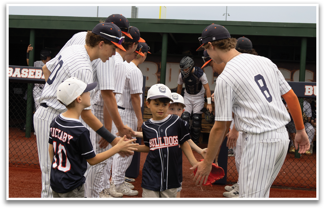 A group of baseball players shake hands with a young boy on the field. Contenido generado con IA