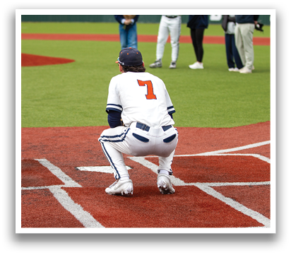 A baseball player is kneeling on the field, wearing a white uniform and a blue hat. Contenido generado con IA