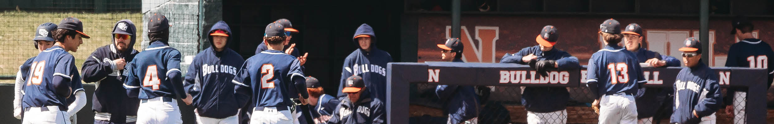 A group of baseball players are standing on the field, some of them wearing blue uniforms. Contenido generado con IA