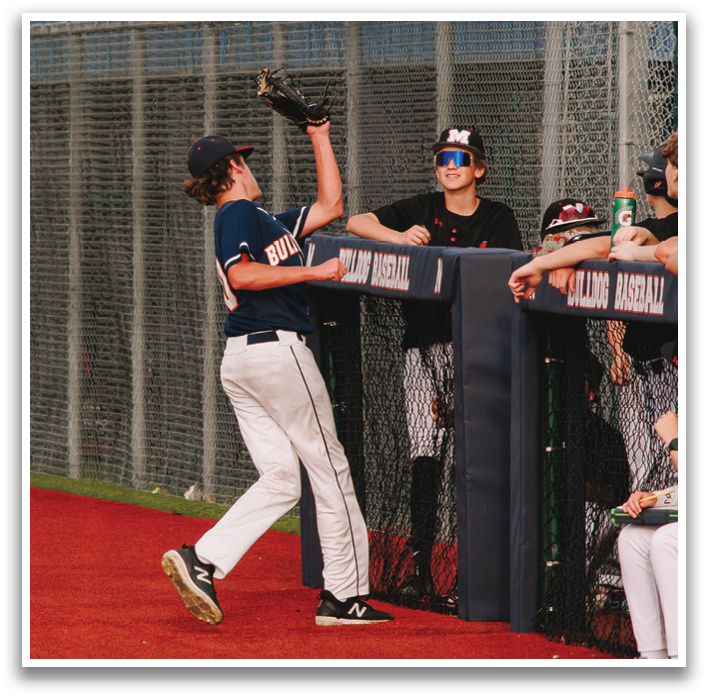 A baseball player in a blue shirt is reaching for a ball with his glove. Contenido generado con IA