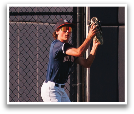 A baseball player in a blue shirt and white pants catching a ball. Contenido generado con IA