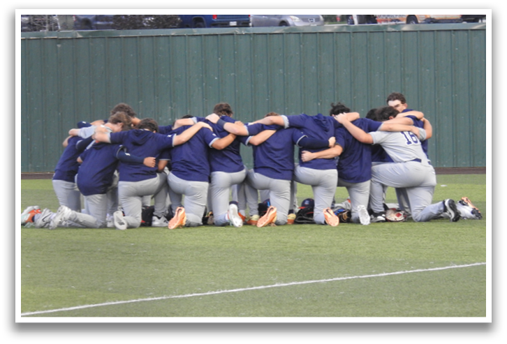 A group of baseball players huddle together on the field, wearing blue and grey uniforms. Contenido generado con IA