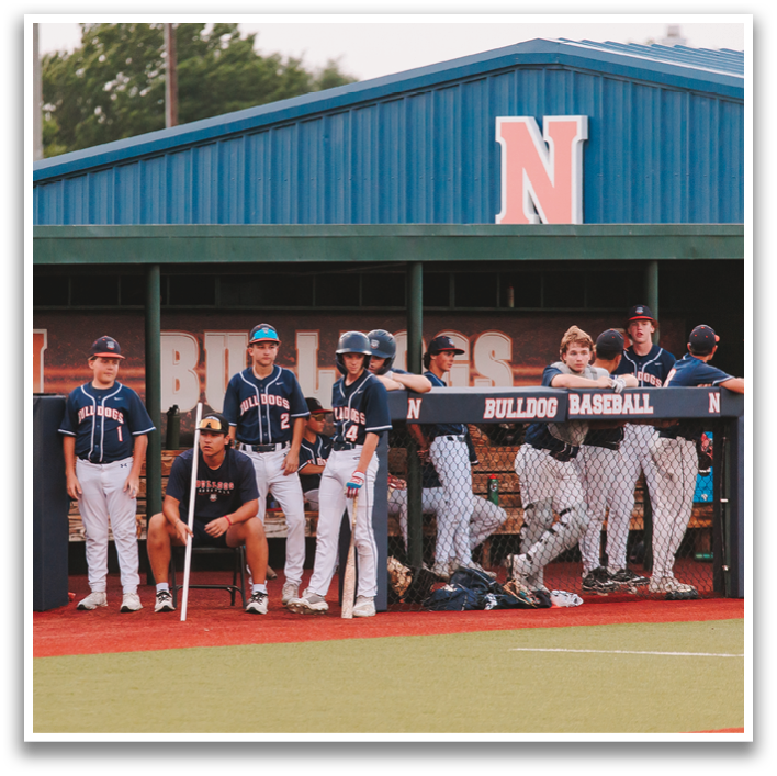 A group of baseball players are sitting on a bench in the dugout. Contenido generado con IA