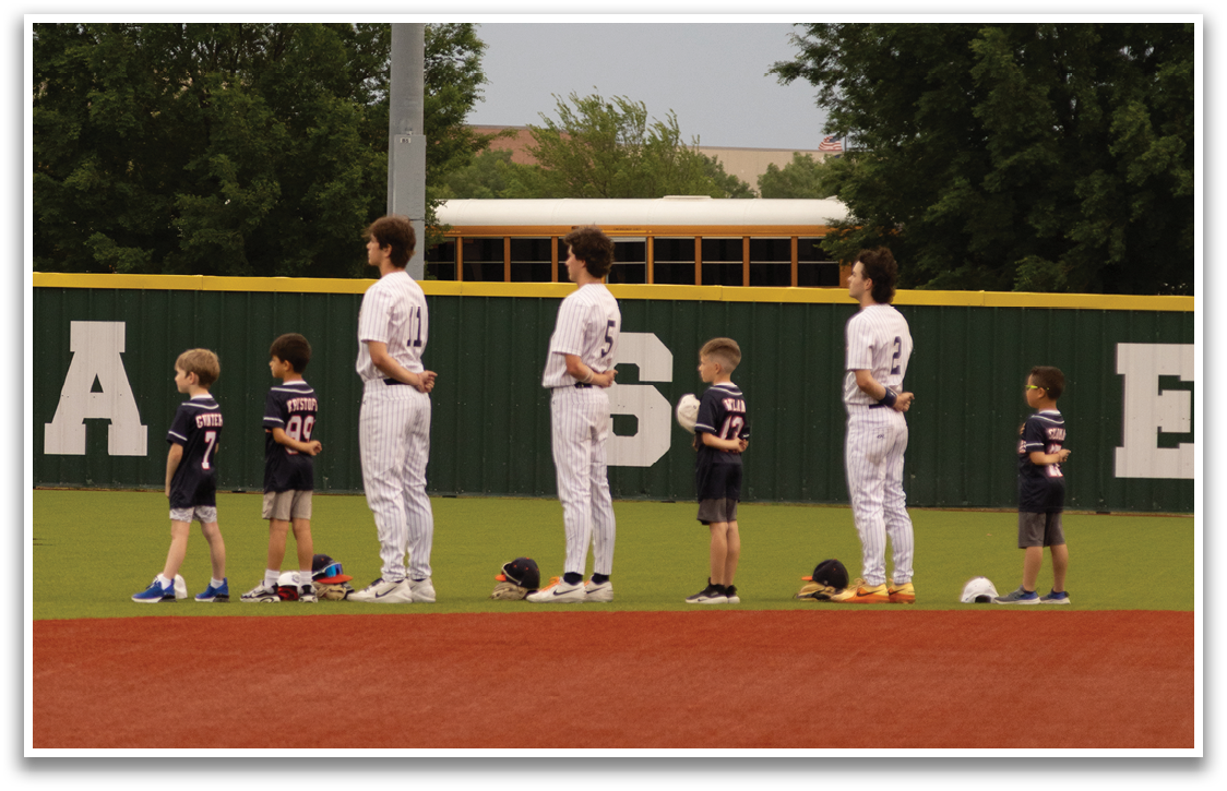 A group of people, including children, are standing on a baseball field. Contenido generado con IA