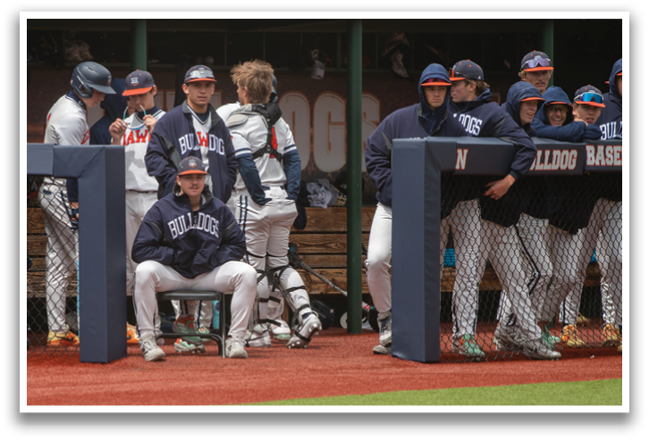 Baseball players are sitting on a bench, some wearing helmets. Contenido generado con IA