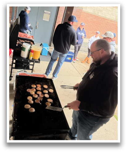 A group of people are gathered around a grill, cooking food. Contenido generado con IA
