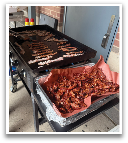A person is cooking food on a grill outside. Contenido generado con IA