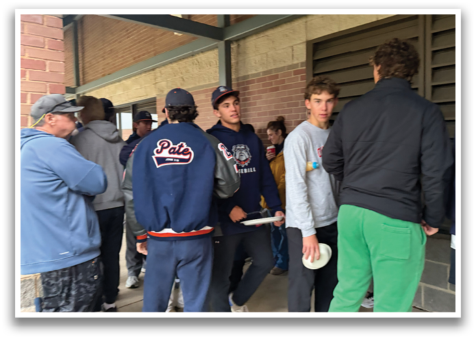 A group of people are standing outside a building, some of them holding frisbees. Contenido generado con IA