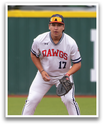 A baseball player wearing a white jersey with the number 17 on it is crouched down on the field, ready to catch a ball. Contenido generado con IA