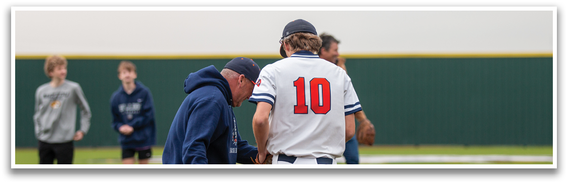 A baseball player wearing a number 10 jersey talks to a coach on the field. Contenido generado con IA