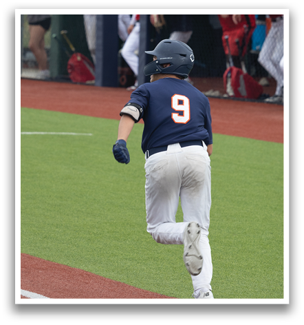 A baseball player wearing a blue shirt with the number 9 on it is running to first base. Contenido generado con IA