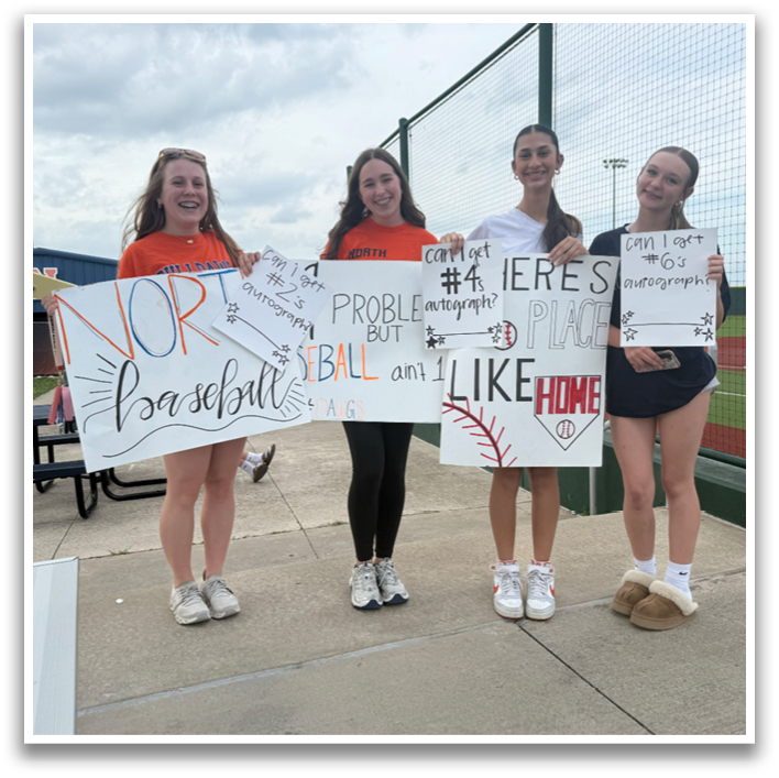 Four girls are standing on a baseball field holding signs. Contenido generado con IA