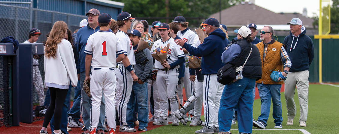 A group of people, including baseball players, are standing on a field. Contenido generado con IA