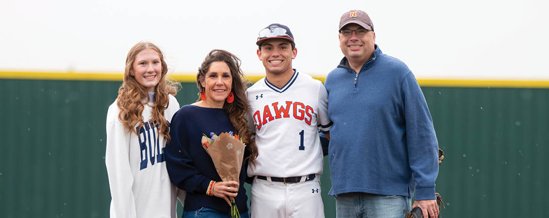 A man, woman, and girl pose for a photo on a baseball field. The man is holding a baseball bat. Contenido generado con IA