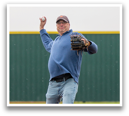 A man in a blue shirt and cap is pitching a baseball on a field. Contenido generado con IA