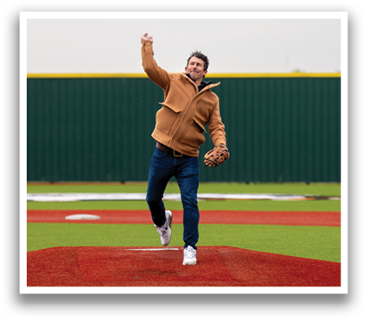 A man in a brown jacket is pitching a baseball on a field. Contenido generado con IA