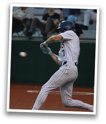 A baseball player in a white uniform is swinging a bat at a ball. Contenido generado con IA