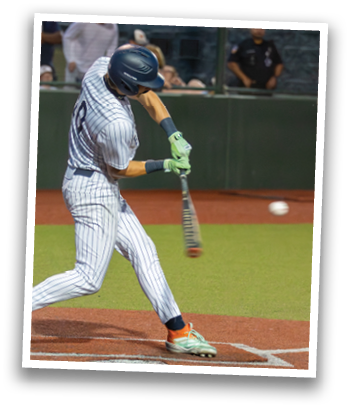 A baseball player in a blue and white uniform is swinging a bat at a ball. Contenido generado con IA