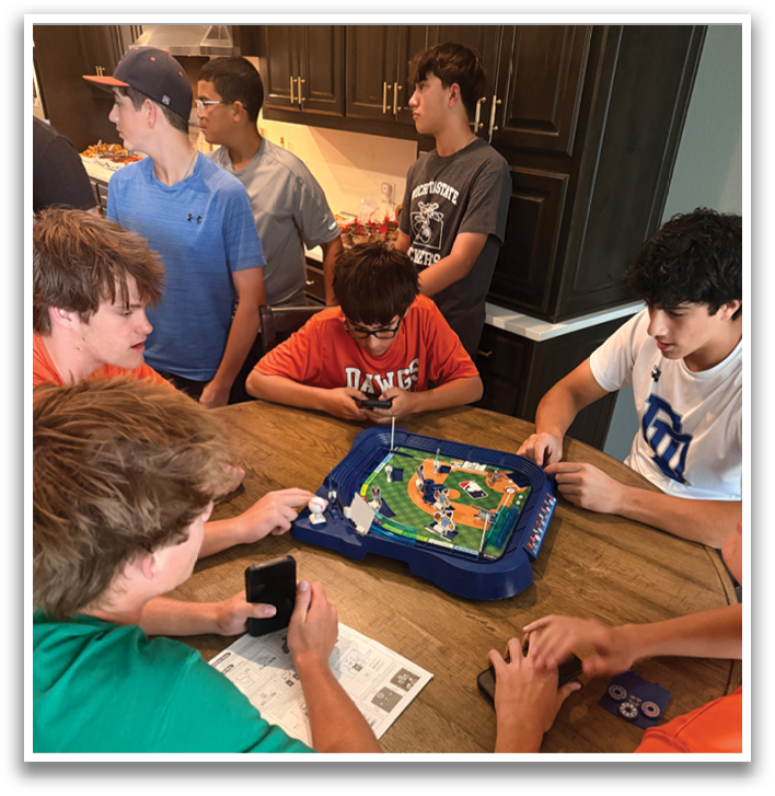 A group of people are gathered around a table playing a game. Contenido generado con IA