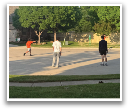 A group of people are playing a game of frisbee in a driveway. Contenido generado con IA