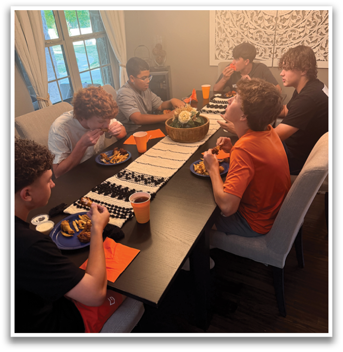 A group of people are sitting around a dining table, enjoying a meal together. Contenido generado con IA