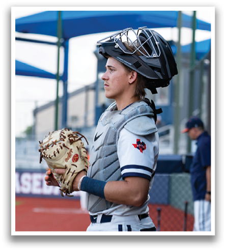 A baseball player wearing a catcher's mitt and chest protector stands on the field. Contenido generado con IA