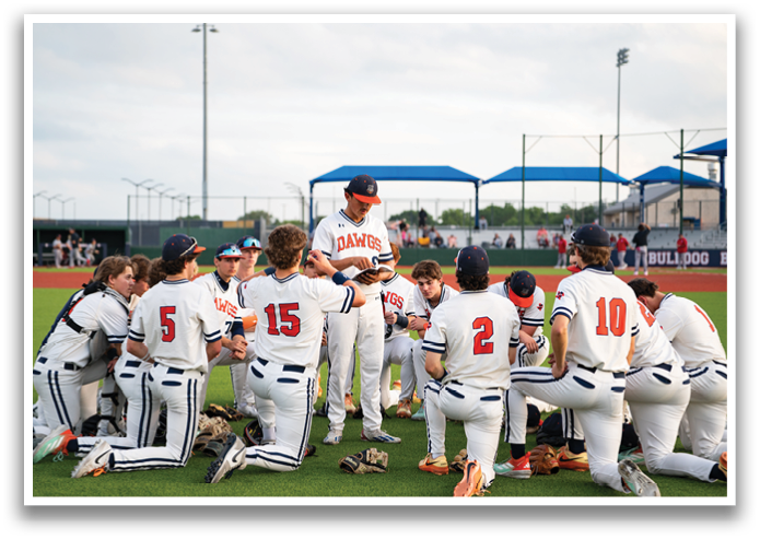 A group of baseball players are kneeling on the field, listening to their coach. Contenido generado con IA