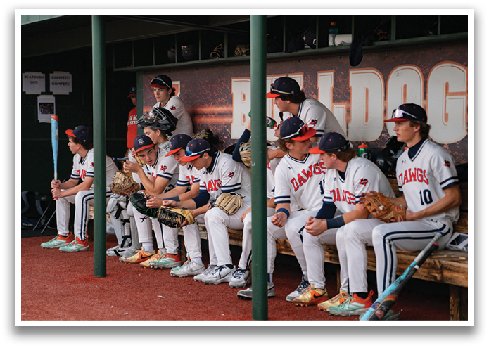 Baseball players sitting on benches, some wearing helmets. Contenido generado con IA