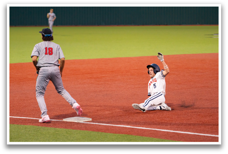 A baseball player slides into home plate while another player tries to catch the ball. Contenido generado con IA