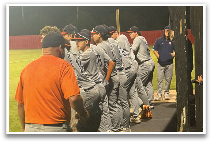 A group of baseball players are standing on the field, some wearing orange shirts. Contenido generado con IA