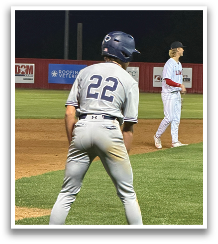 A baseball player in a grey uniform is standing on the field, holding a bat and getting ready to hit the ball. Contenido generado con IA