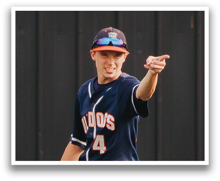 A baseball player wearing a blue shirt and white pants is pointing to the sky. Contenido generado con IA