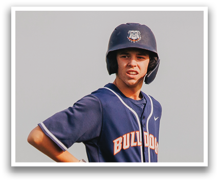 A baseball player wearing a blue and white uniform stands on the field, holding a bat. Contenido generado con IA