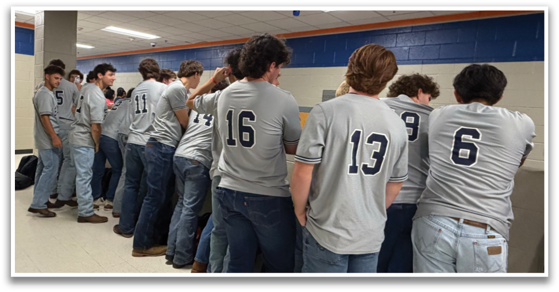 A group of young men wearing grey shirts and jeans are standing in a line. Contenido generado con IA