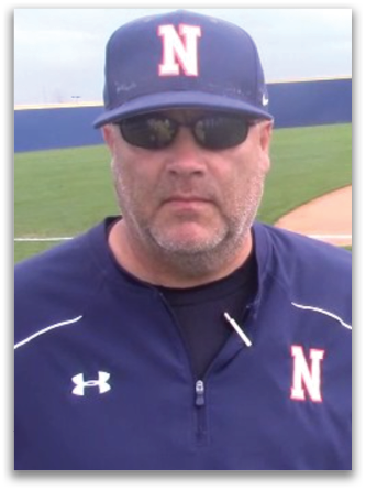 A man wearing a blue and white baseball cap and sunglasses standing on a baseball field. Contenido generado con IA