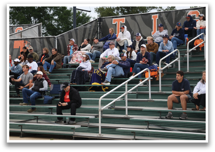 A crowd of people are sitting on a bench at a baseball game. Contenido generado con IA