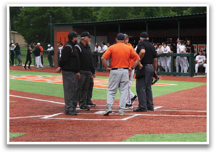 A group of men are standing on a baseball field, engaged in conversation. Contenido generado con IA