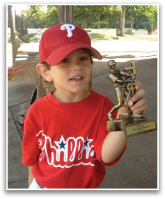 A young boy wearing a red baseball cap and a red shirt holding a trophy. Contenido generado con IA