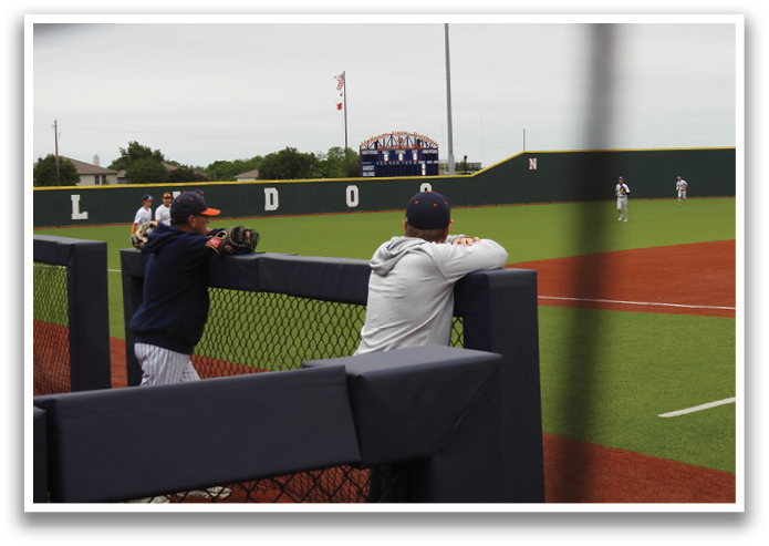 A man is sitting on a bench in a baseball field, watching the game. Contenido generado con IA