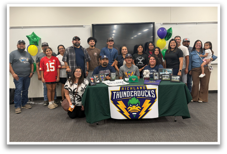 A group of people pose for a photo in front of a table with a Thunderducks sign. Contenido generado con IA