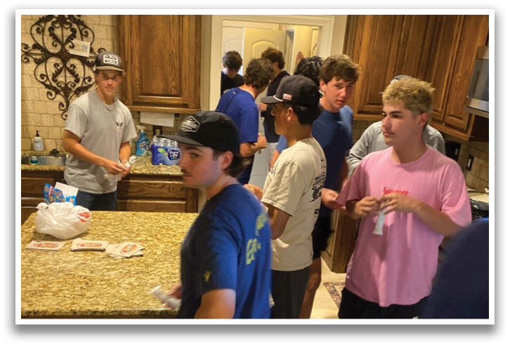 A group of people are gathered in a kitchen, standing around a counter. Contenido generado con IA