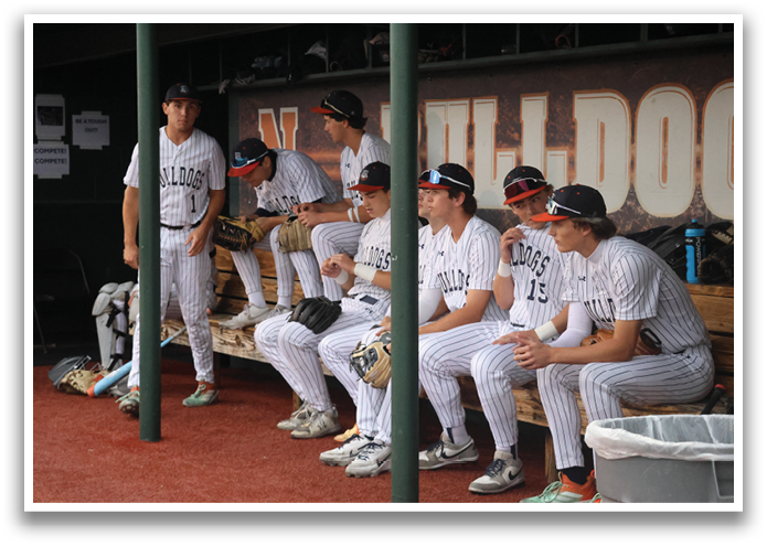 A group of people are sitting on a bench, watching a baseball game. Contenido generado con IA