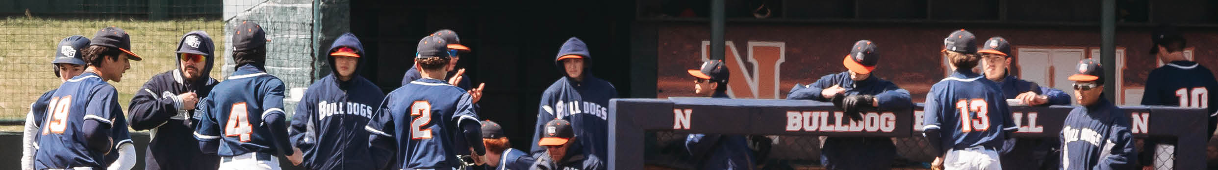 A group of baseball players are standing on the field, some of them wearing blue uniforms. Contenido generado con IA