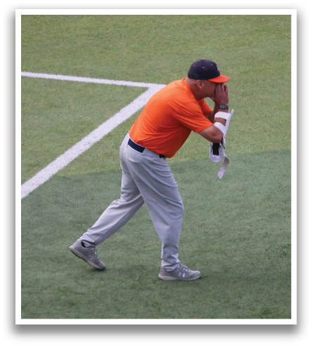 A man in an orange shirt is swinging a baseball bat on a field. Contenido generado con IA