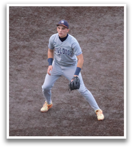 A baseball player in a grey uniform is standing on the field, holding a baseball glove. Contenido generado con IA