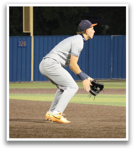 A baseball player in a grey uniform is kneeling on the field, holding a baseball glove. Contenido generado con IA