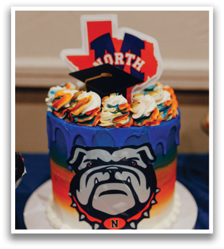 A cake with a bulldog mascot on it is decorated with a blue and orange color scheme. Contenido generado con IA