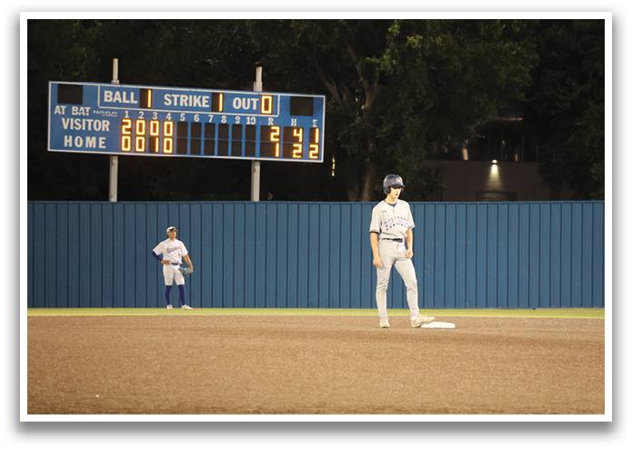 A baseball player stands on the field, wearing a helmet and holding a bat. Contenido generado con IA